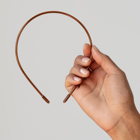 L. Erickson headband beside coin for scale, compact travel-friendly size