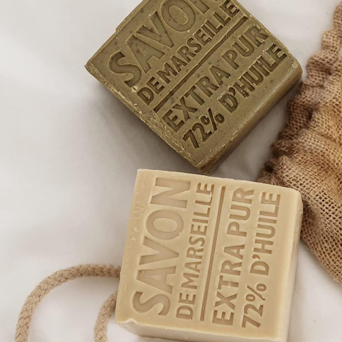 La Compagnie de Provence soap cube held in hand for scale showing large, long-lasting olive oil bar