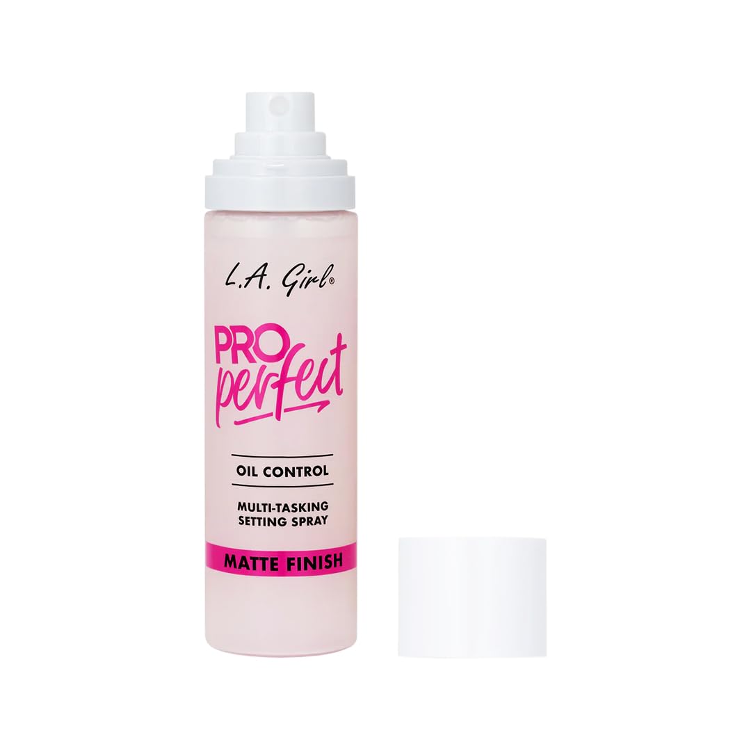 L.A. Girl bottle next to travel essentials showing compact size and portability