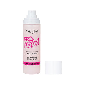 L.A. Girl bottle next to travel essentials showing compact size and portability