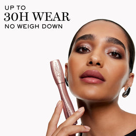 Lancôme mascara next to a credit card showing travel-size convenience benefit