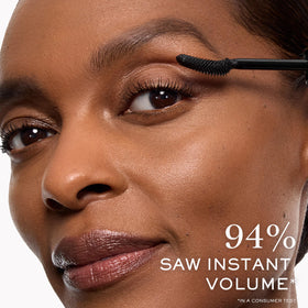 Lancôme mascara held in hand for scale, indicates travel-size convenience