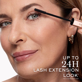 Lancôme travel-size mascara in hand for scale and portability benefit