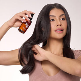 L'ANGE HAIR bottle in hand to show product size and portability