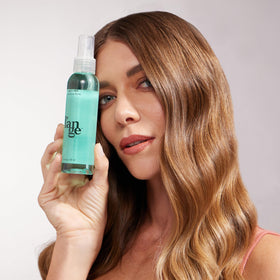 L'ANGE HAIR applying spray to damp hair to create natural waves