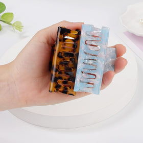 LAXIZAR clip held in hand showing three-inch scale for size clarity