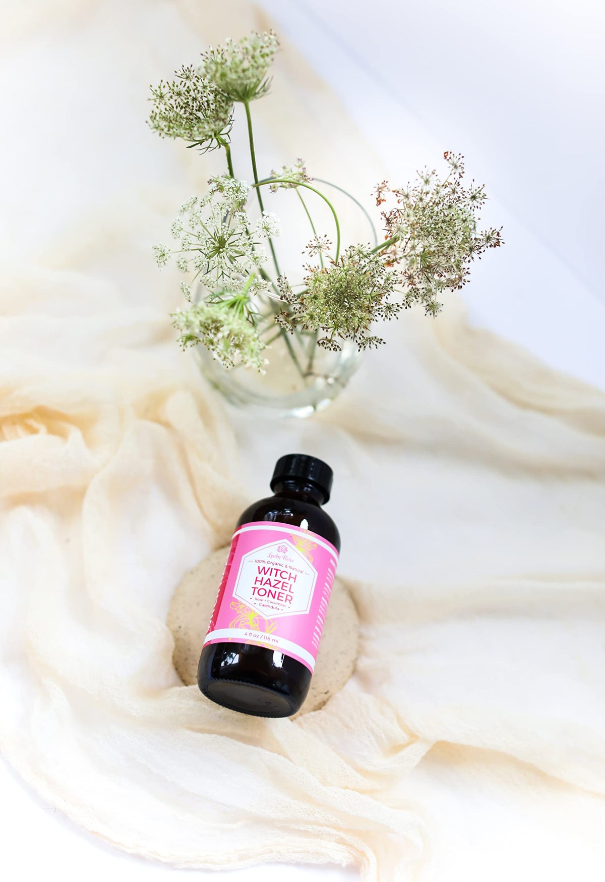 Leven Rose bottle in hand showing 4 oz scale for travel-friendly benefit