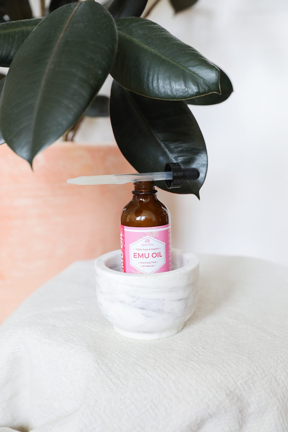 Leven Rose bottle beside a ruler showing 4 oz scale for sizing and travel planning