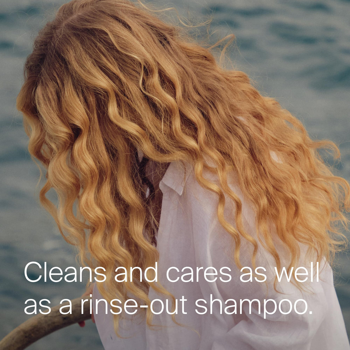 Living Proof applying spray to roots to absorb oil and refresh hair benefit