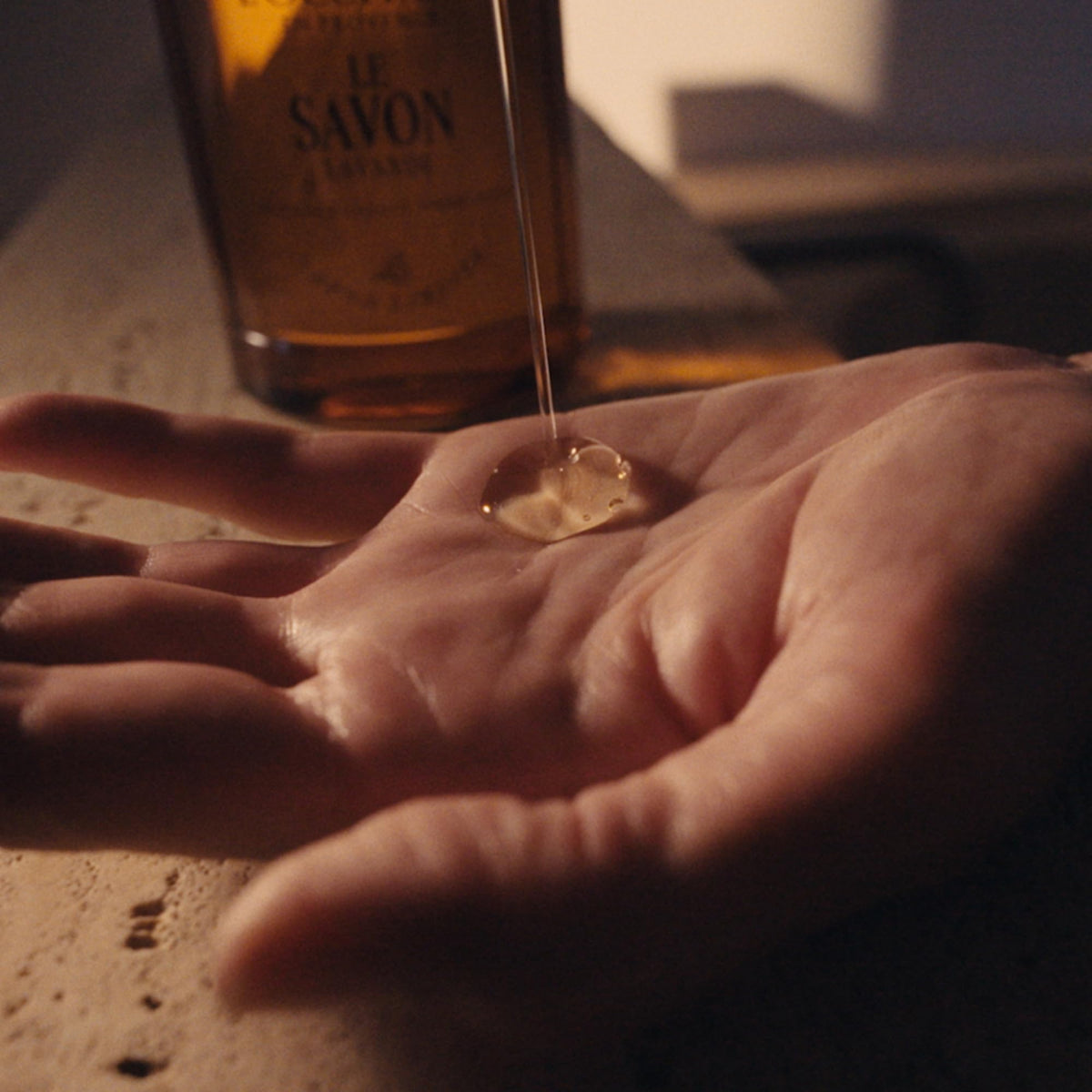 L'OCCITANE bottle next to hand for size and usage clarity benefit