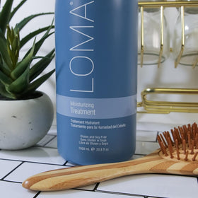Loma 12 ounce conditioner shown next to hand for size and travel-friendly benefit