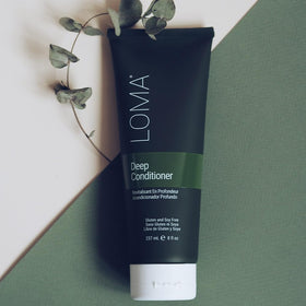 LOMA deep conditioner bottle next to baobab fruit showing natural ingredients and ingredient clarity
