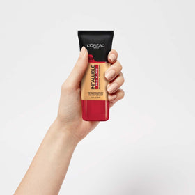 L'Oreal Paris bottle held in hand demonstrating 1 oz travel-friendly size