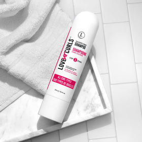 Love Ur Curls 8.5 oz bottle next to common item showing compact travel-friendly size