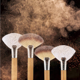Lusofie fan brush applying highlighter on cheek demonstrating blendable, natural sheen