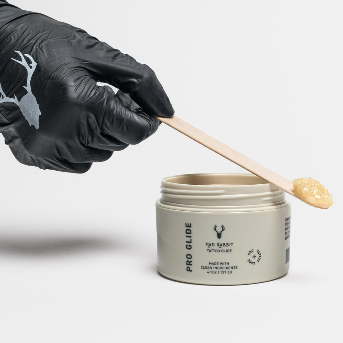Mad Rabbit Glide jar held in hand to show size and travel-friendly benefit