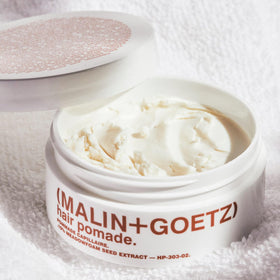 MALIN+GOETZ pomade texture close-up warming between fingers for application