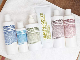 MALIN+GOETZ moisturizer being smoothed onto skin showing calming and hydrating benefit