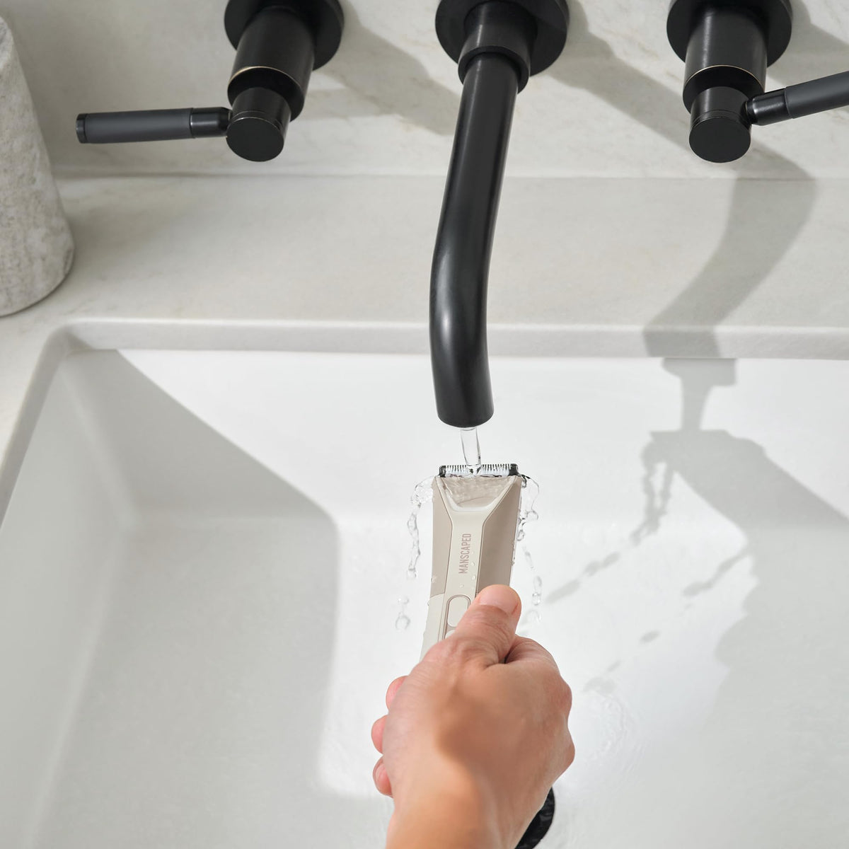 MANSCAPED trimmer in shower demonstrating waterproof IPX7 rating for wet cleaning