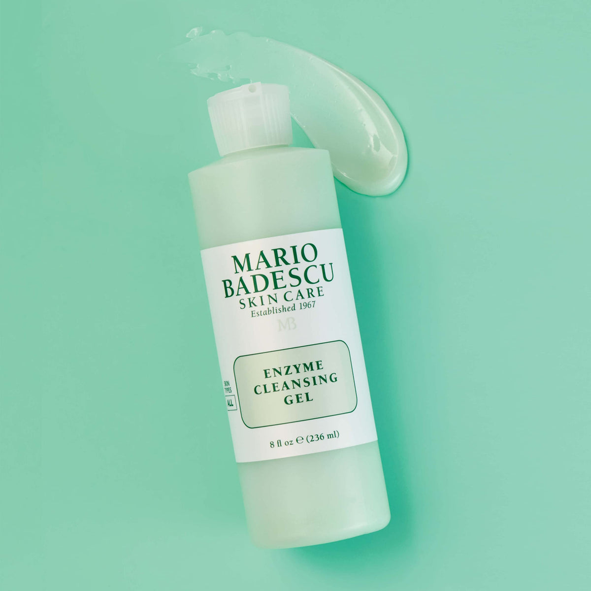 Mario Badescu 16 fl oz bottle beside everyday items for size and value