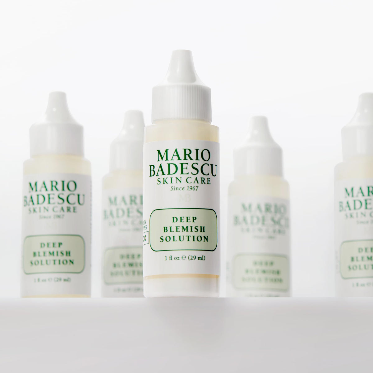 Mario Badescu bottle held next to a ruler showing 1 fl oz scale and travel-friendly size