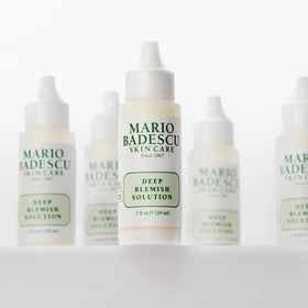 Mario Badescu bottle held next to a ruler showing 1 fl oz scale and travel-friendly size