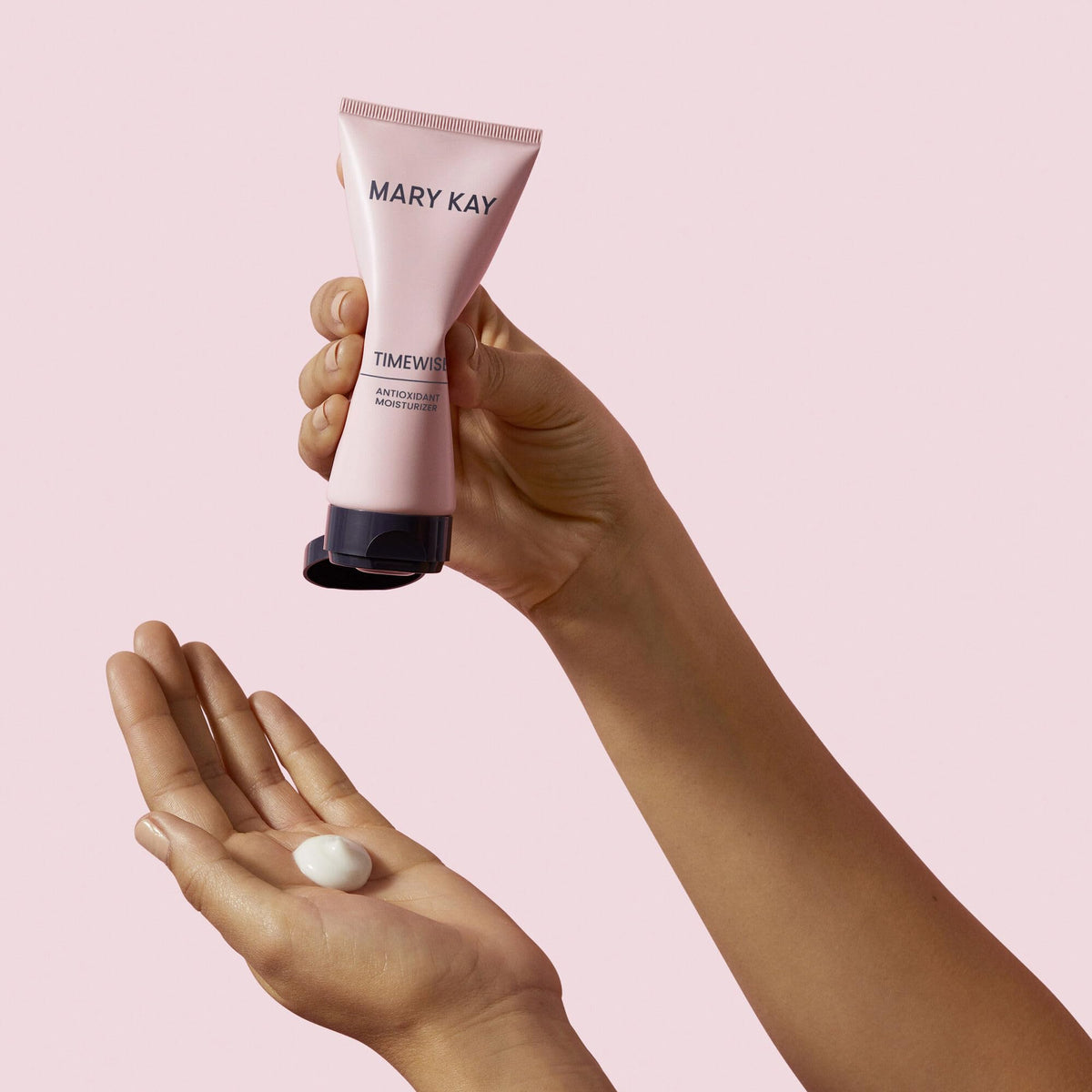 Mary Kay TimeWise tube next to hand for scale showing compact size and travel-friendly convenience
