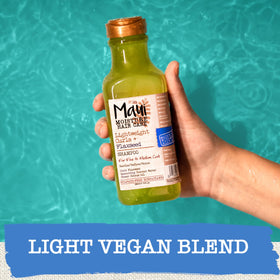 Maui Moisture bottle in hand showing 13 fl oz scale and portability