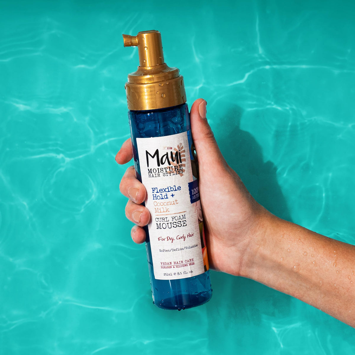 Maui Moisture bottle beside hand for scale showing convenient 8.5oz size