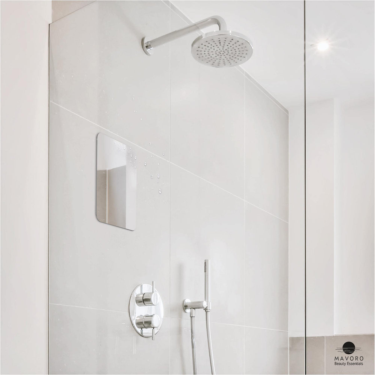 Hand holding Mavoro 7x9 mirror to show scale and lightweight easy-placement benefit