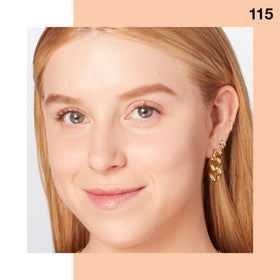 Woman applying Maybelline foundation in mirror showing natural luminous finish