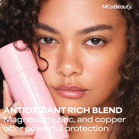 MCoBeauty 100ml bottle beside common items to show compact travel-friendly size