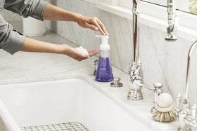 Method bottle held next to a hand for scale, indicates compact 10 fl oz size