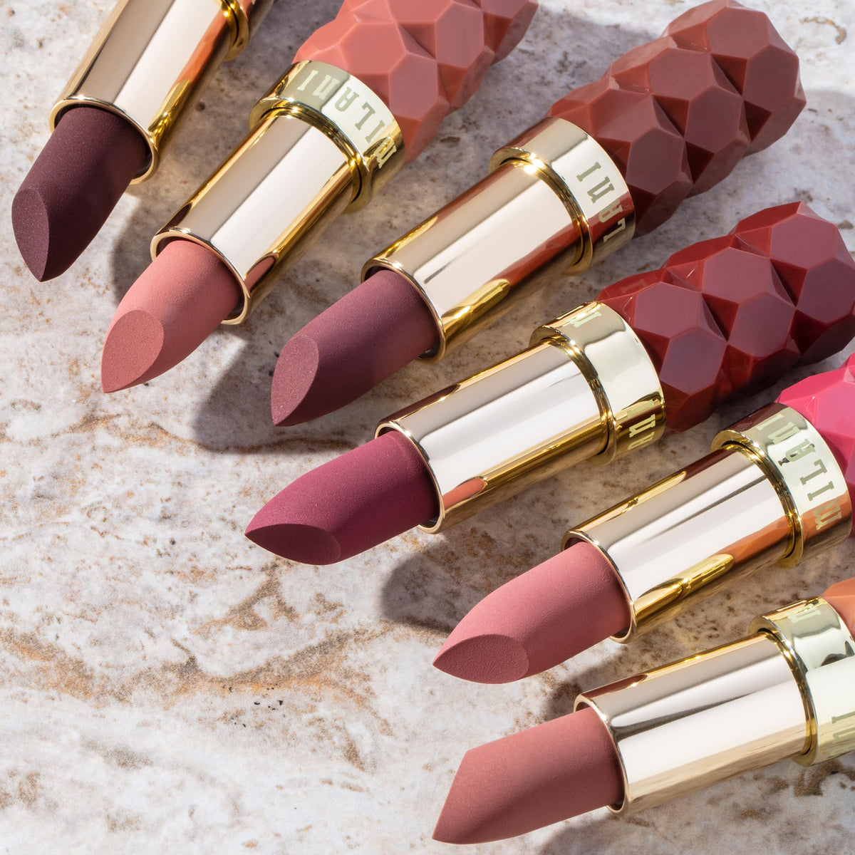 Milani lipstick next to coin size comparison showing compact travel-friendly benefit
