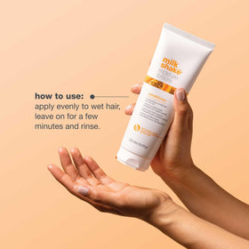 milk_shake 8.1 fl oz bottle next to a hand for size scale and travel-friendly convenience