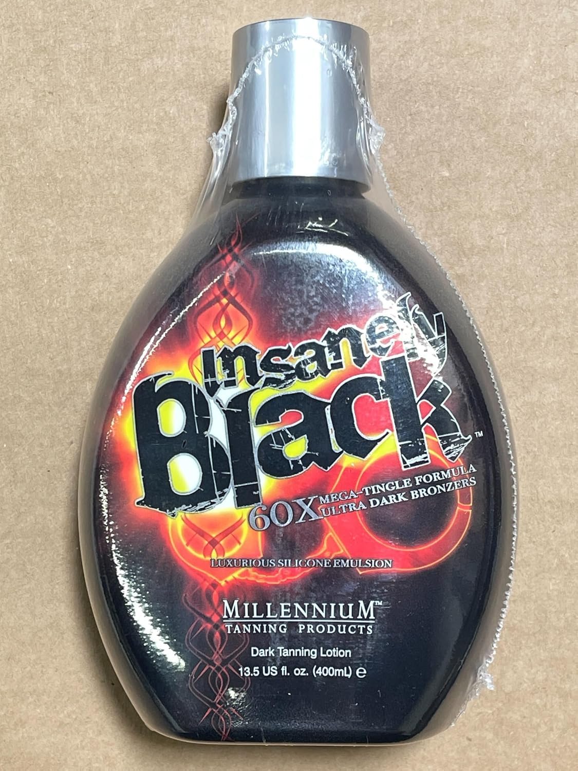 Millennium Tanning bottle on beach towel evoking outdoor bronzed lifestyle