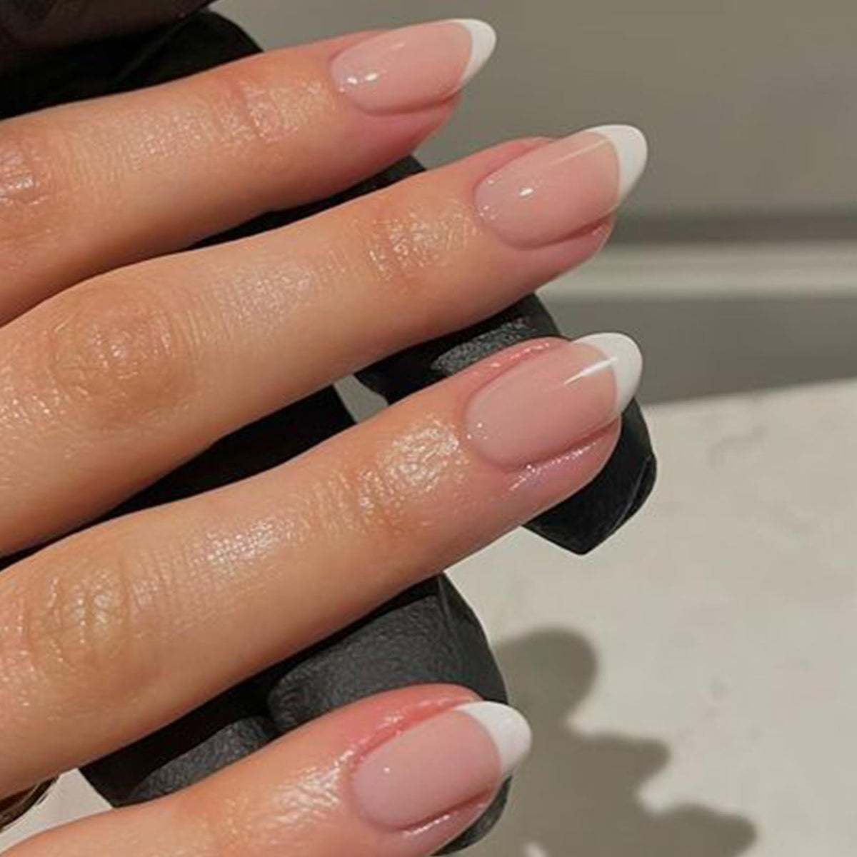 modelones close-up of short oval French tip nails showing clean edges and natural look