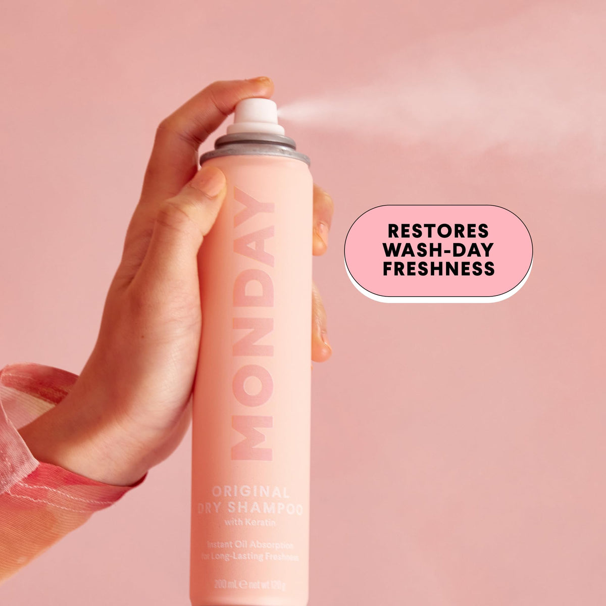 MONDAY HAIRCARE held in hand for scale showing compact 200 mL travel-ready size