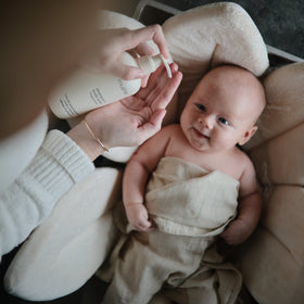mushie in baby bathroom use showing parent applying wash for calming bath