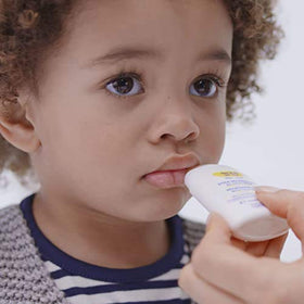 Mustela nourishing stick being applied to baby cheek to soothe and protect skin