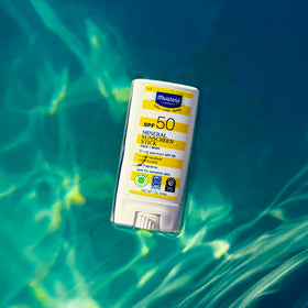 Mustela stick beside sun hat illustrating family sun-safety routine