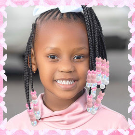 NAISKA beads threaded on a child’s braid adding color and playful detail