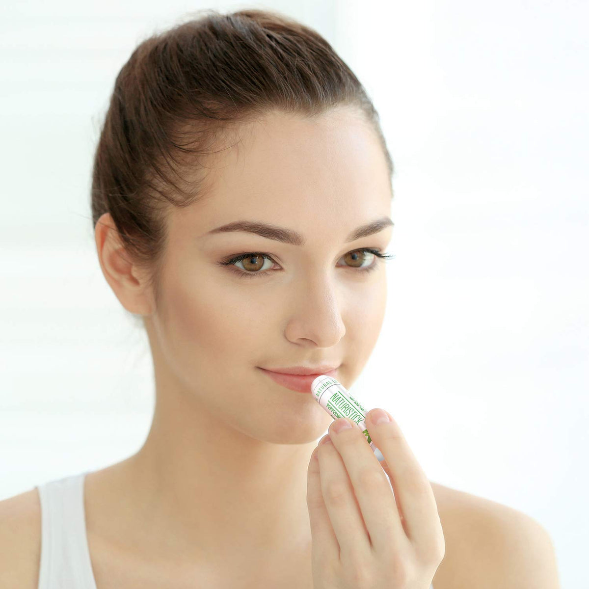 Naturistick single tube close-up revealing smooth balm surface and easy application