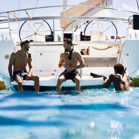 Nautica Blue bottle on a beach backdrop suggesting fresh, outdoor summer wear