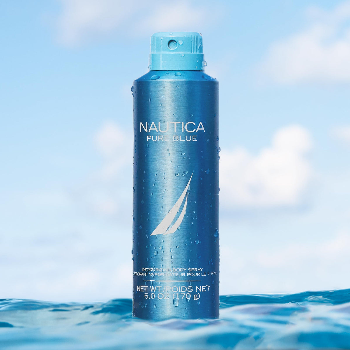 Hand spraying Nautica Pure Blue body spray demonstrating easy daily application