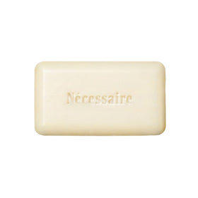 Nécessaire front packaging showing compact exfoliant bar for travel convenience