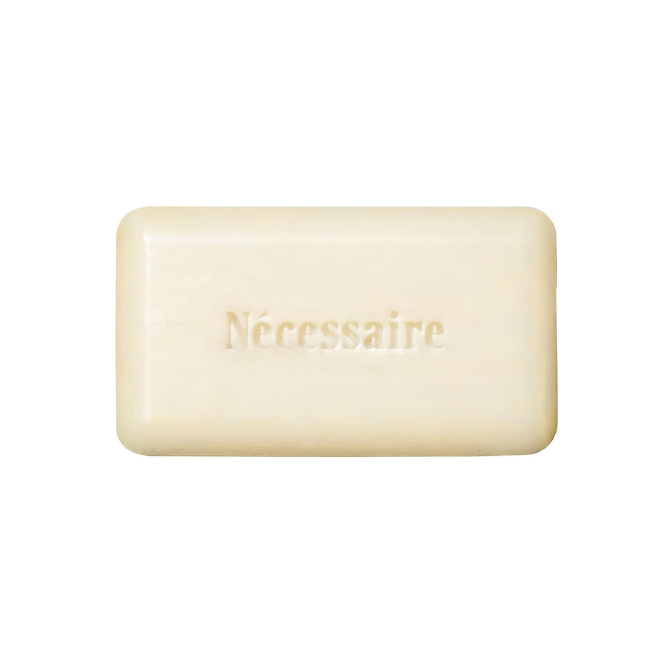Nécessaire front packaging showing compact exfoliant bar for travel convenience