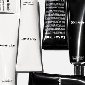 Nécessaire hand retinol balm open pot showing creamy repair texture