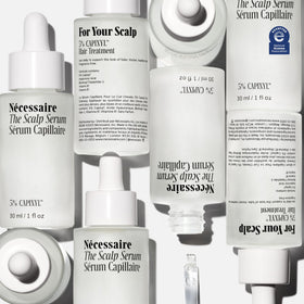 Nécessaire scalp serum pipette close-up displaying water-light texture and precision dispensing for targeted use