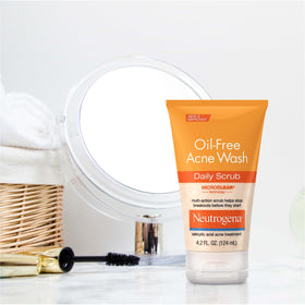 Neutrogena applying scrub to face demonstrating cleansing benefit